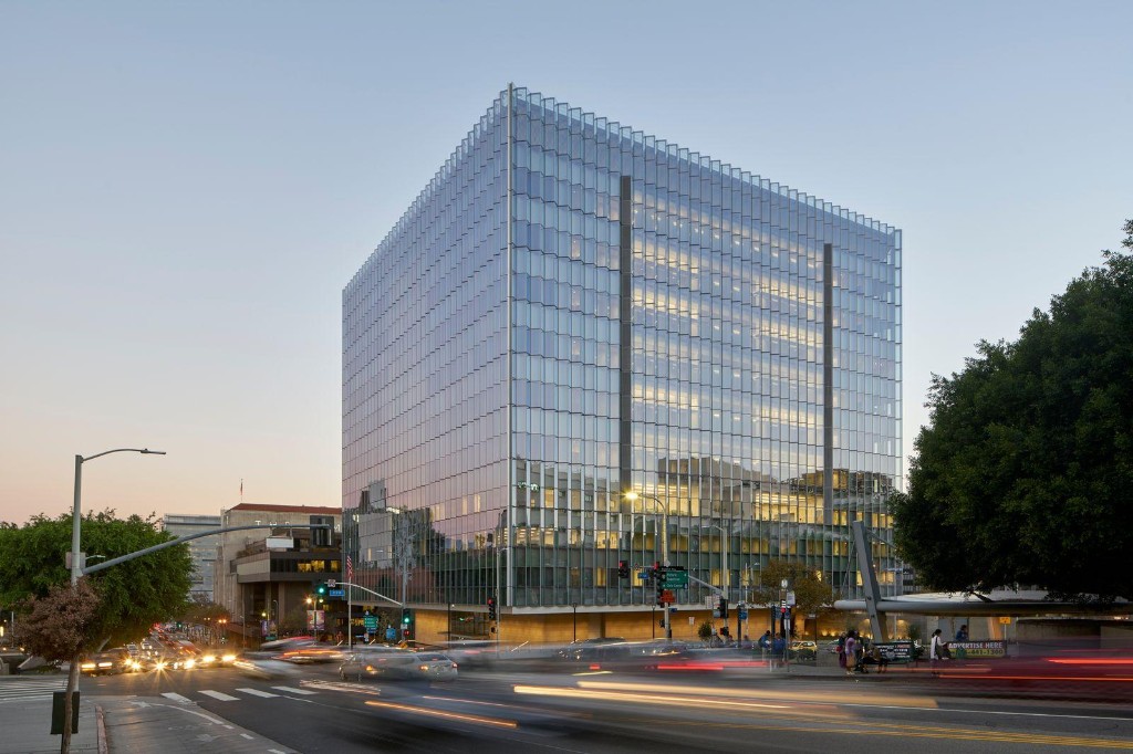 Modern glass civic building at a city intersection at dusk